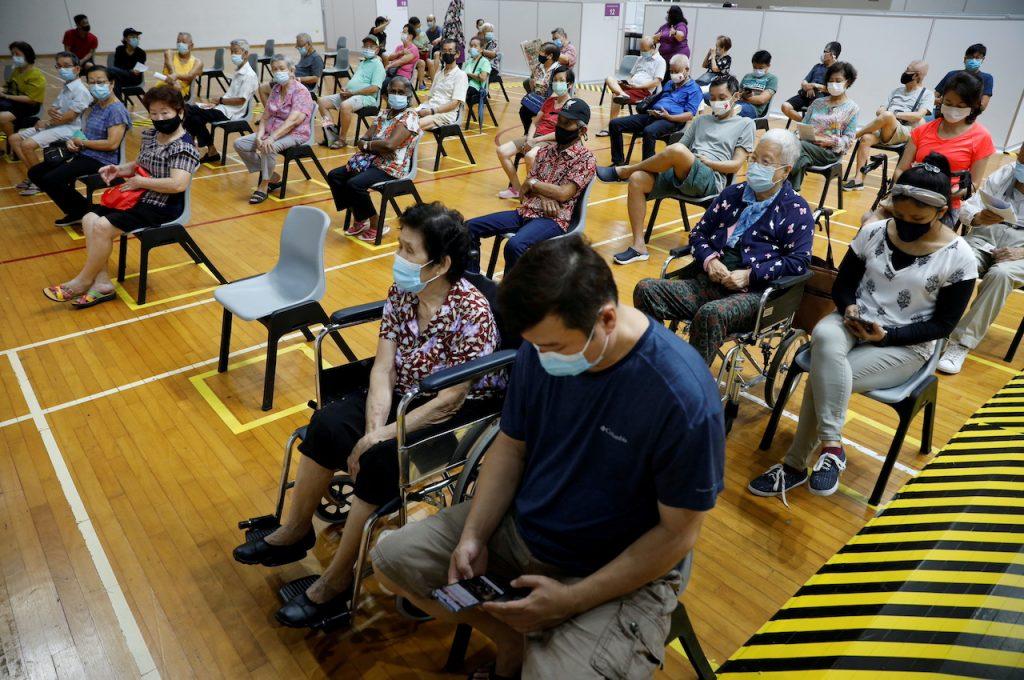 People wait at an observation area after receiving their vaccine jabs at a vaccination centre in Singapore, March 8. Photo: Reuters