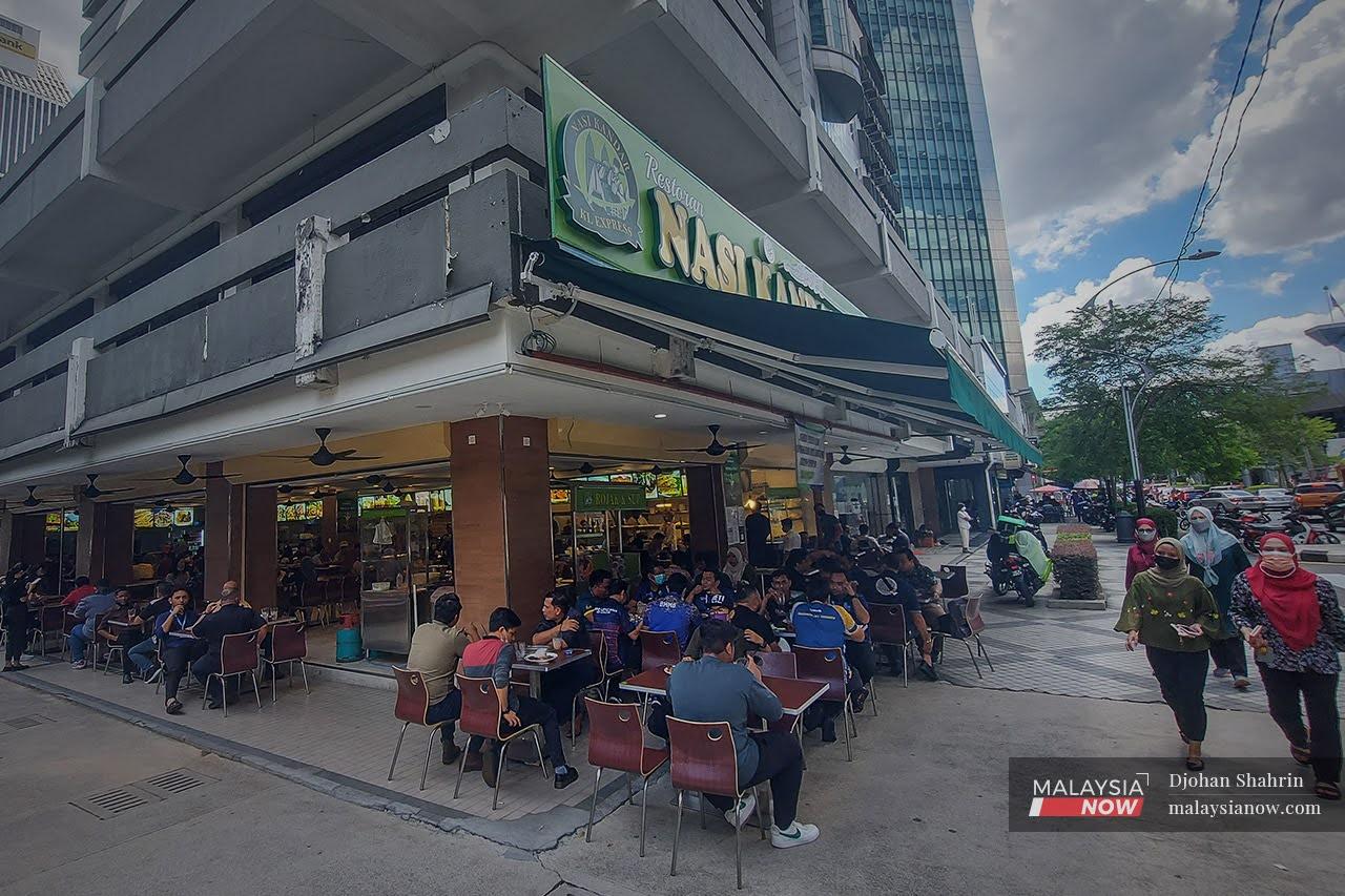 People enjoy a meal at a restaurant in Kuala Lumpur, under Phase Four of the National Recovery Plan.