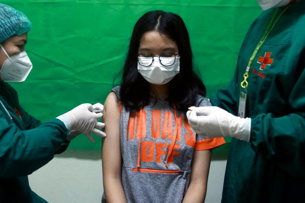 A young girl reacts as medical staff give her a shot of the Sinovac Covid-19 vaccine, July 8. Photo: AP