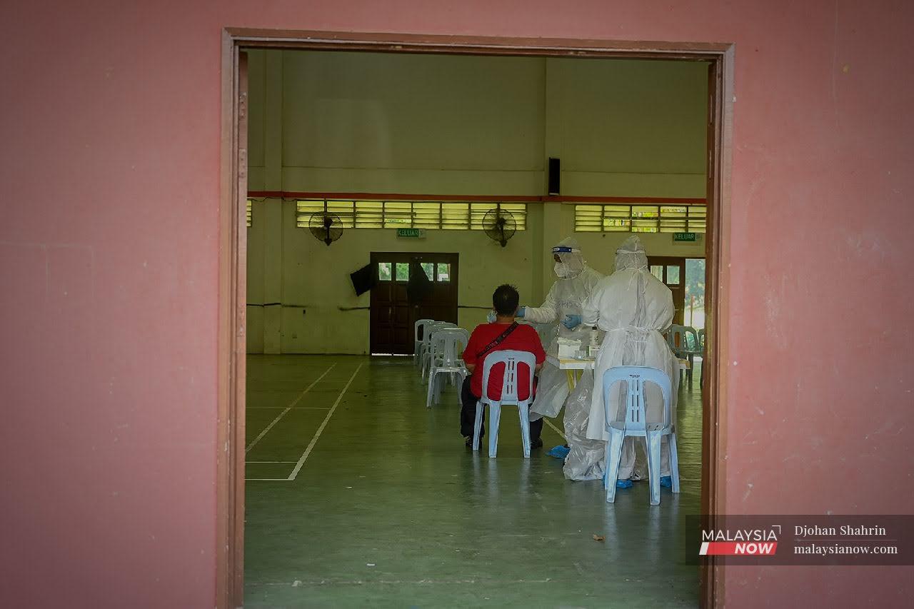 Orang Asli Temuan melakukan ujian saringan RTK-Antigen secara percuma oleh pasukan kesihatan Klinik Selcare di Desa Temuan, Bukit Lanjan.