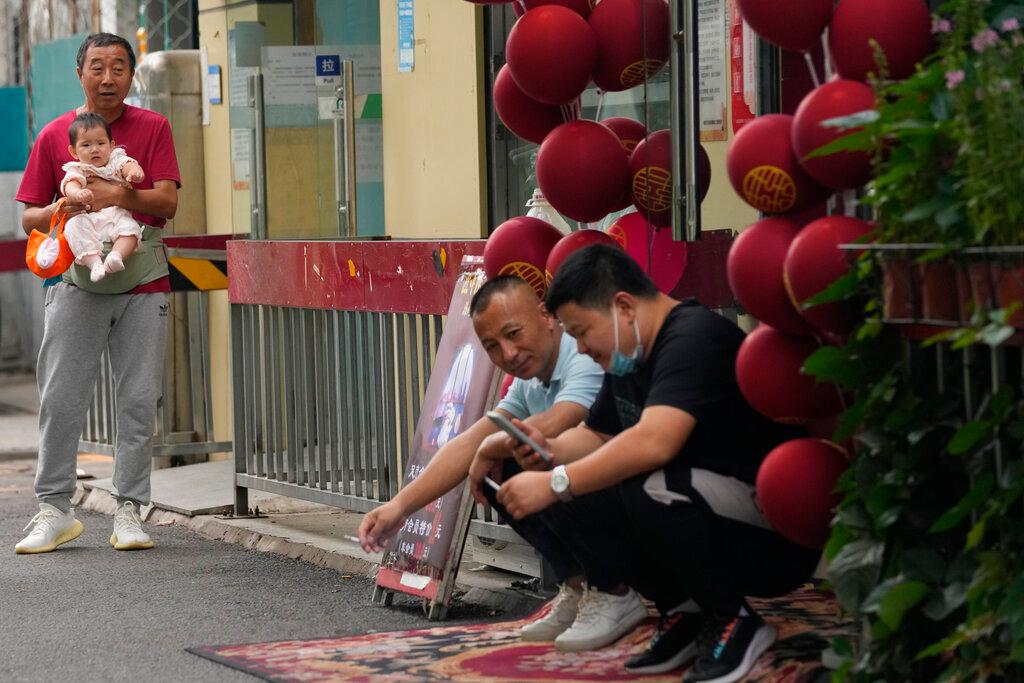 Residents mingle along a street of Beijing, China, Sept 16. Many cities with infections have closed indoor entertainment and cultural venues while a flurry of marathons, theatrical performances and concerts have been delayed or cancelled. Photo: AP