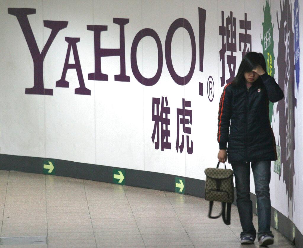 A woman walks past a Yahoo billboard in a Beijing subway in this March 17, 2006. Yahoo's move follows that of Microsoft Corp, which pulled the plug on LinkedIn in China last month, marking the retreat of the last major US-owned social network in China. Photo: AP
