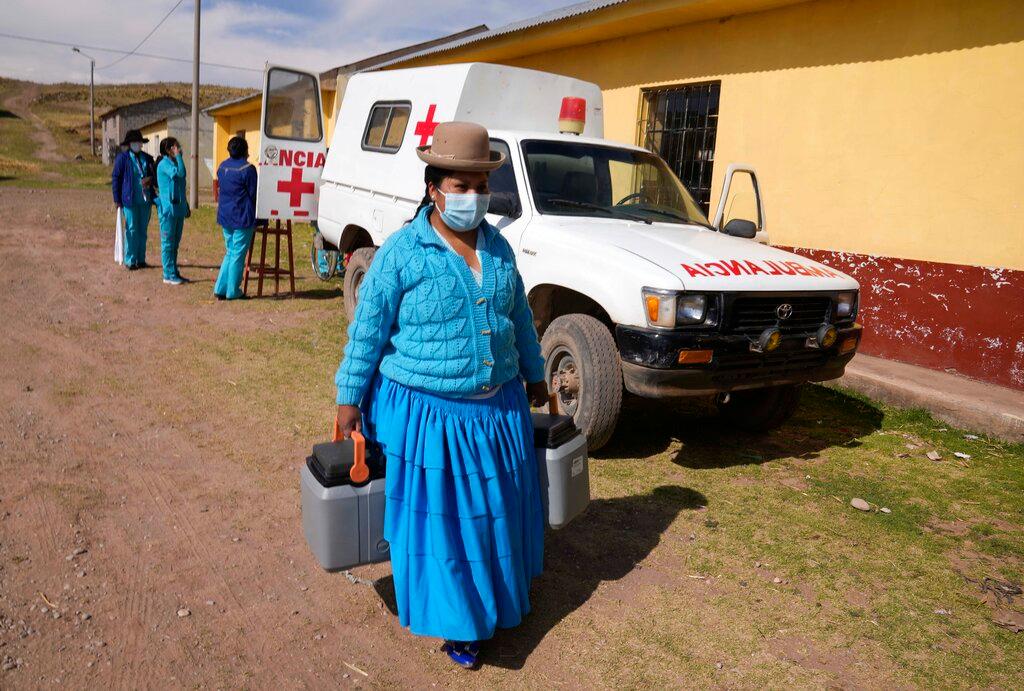 A healthcare worker carries coolers containing doses of the Sinopharm Covid-19 vaccine during a vaccination campaign in Jochi San Francisco, Peru, Oct 29. Photo: AP