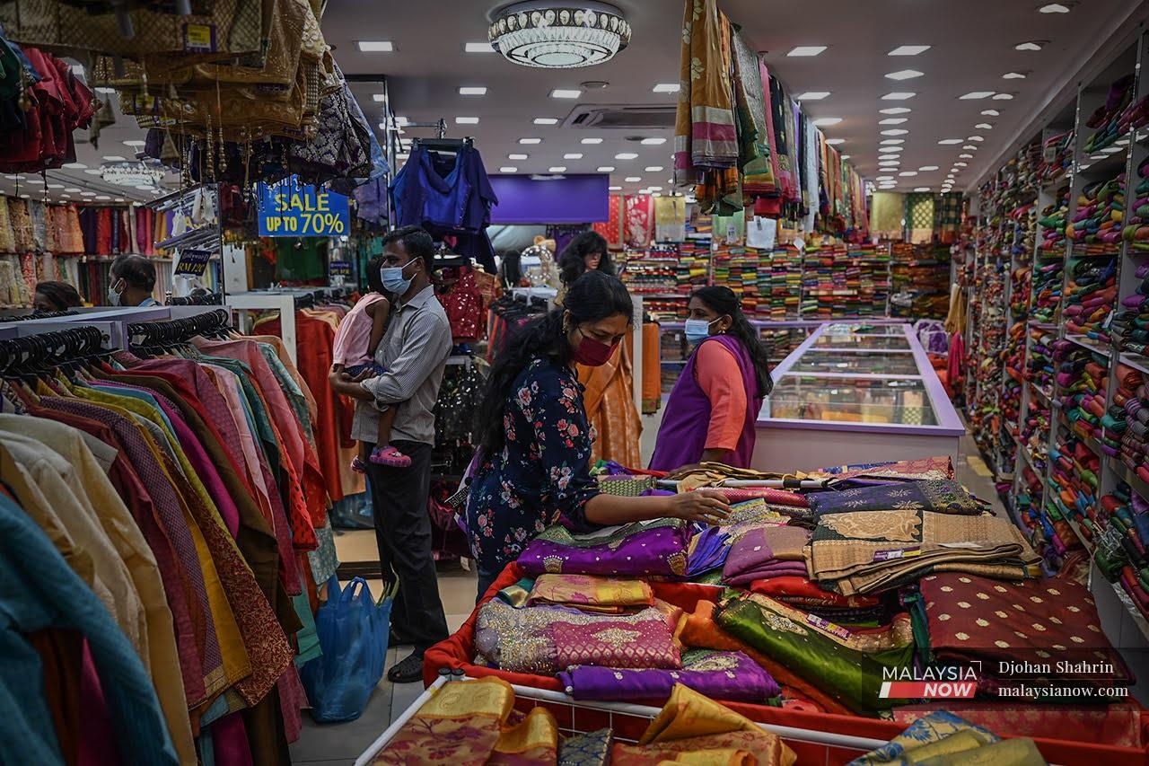 Family members observe health SOPs as they shop for new clothes for Deepavali at a store in Brickfields, Kuala Lumpur.