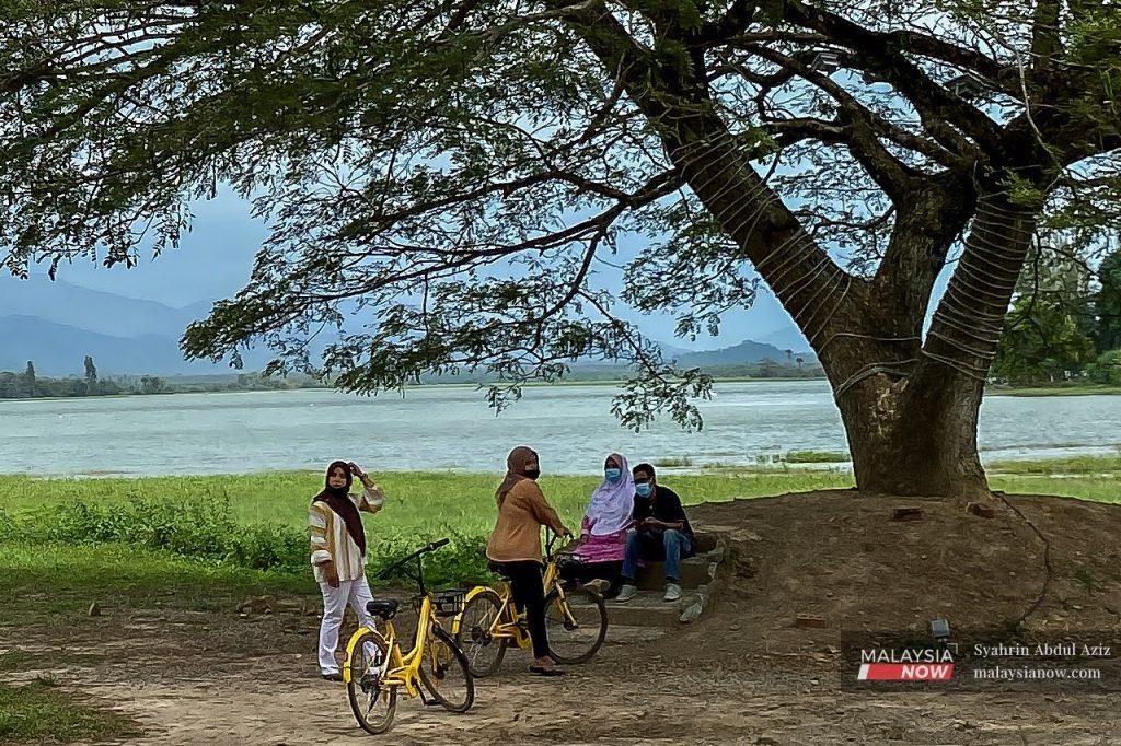 Beberapa pengunjung berehat di bawah pokok selepas beriadah bersama keluarga di Tasik Timah Tasoh. Penduduk Perlis bakal mendapat lebih banyak kelonggaran di bawah Fasa Empat PPN.