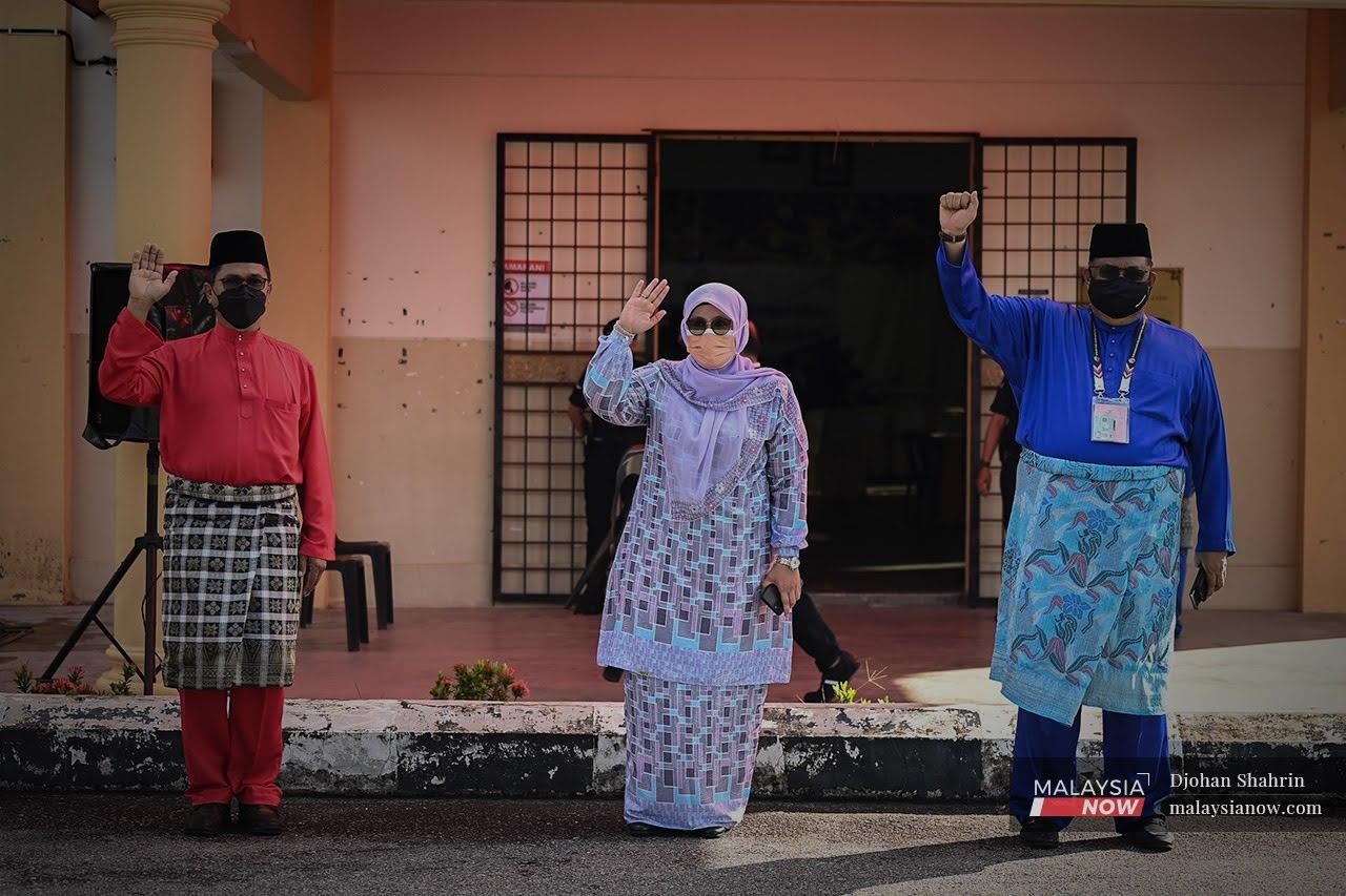Mas Ermieyati Samsudin, Ab Rauf Yusoh and Zainal Hassan gesture outside the nomination centre in Tanjung Bidara, Melaka, today.