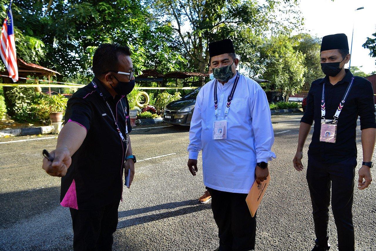 Calon Bebas bagi Dewan Undangan Negeri N10 Asahan, Mohd Akhir Ayob, 50, (tengah) tiba di pusat penamaan calon, Dewan Besar Kolej Komuniti Selandar hari ini. Gambar: Bernama