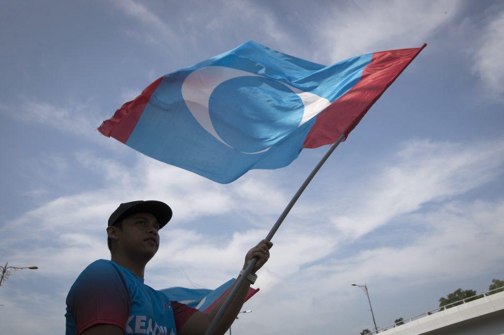 Seorang penyokong PKR mengibarkan bendera parti itu. Kerjasama antara PH dan PSB tergendala menjelang PRN Sarawak yang dijangka diadakan selepas PRN Melaka. Gambar: AP