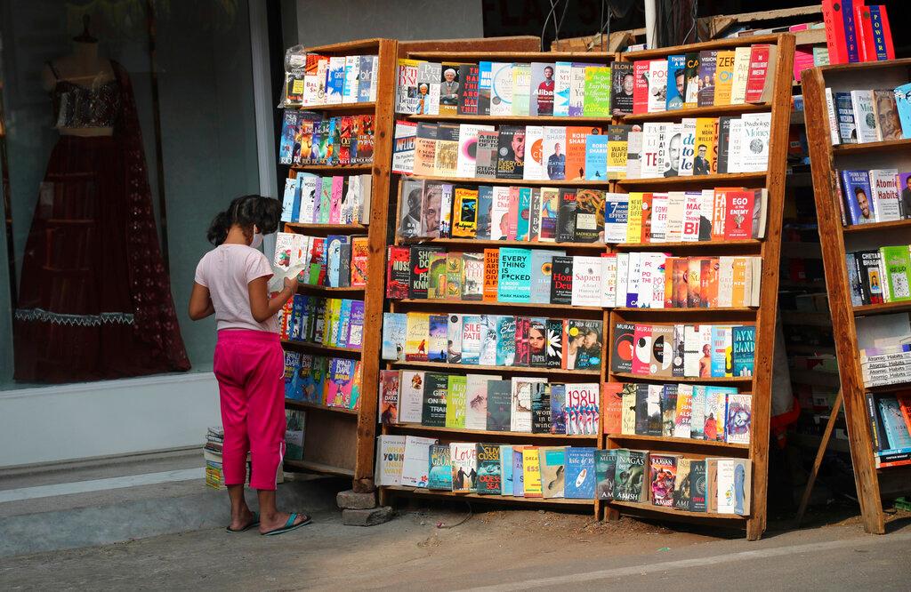 An Indian girl goes through a book at a roadside book stall in Hyderabad, India, Nov 7. The Paytm platform was launched in 2010 and quickly became synonymous with digital payments in a country traditionally dominated by cash transactions. Photo: AP