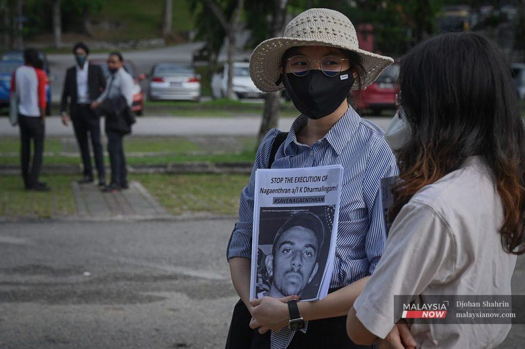 An activist holds a picture of Nagaenthran K Dharmalingam at a gathering at the Parliament building in Kuala Lumpur last week.