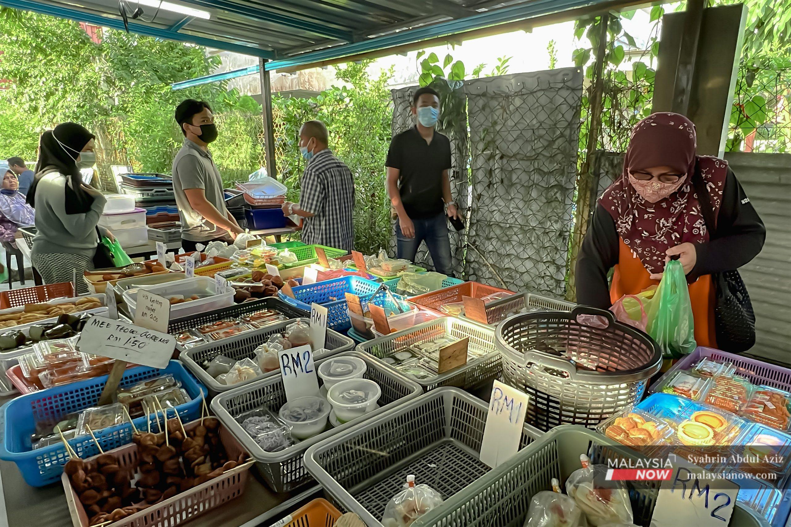 Pelawat tempatan di Terengganu beratur mengikuti SOP penjarakan jarak untuk membeli sarapan di sebuah gerai.