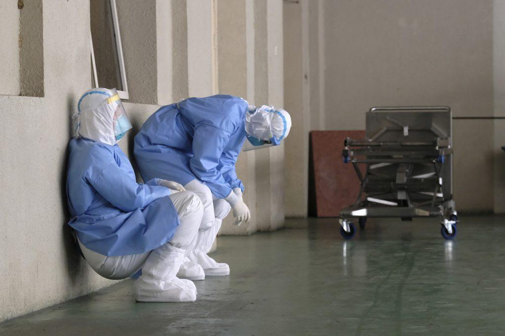 Petugas kesihatan lengkap berpakaian PPE duduk bagi melepaskan penat sewaktu bertugas. Gambar: Bernama