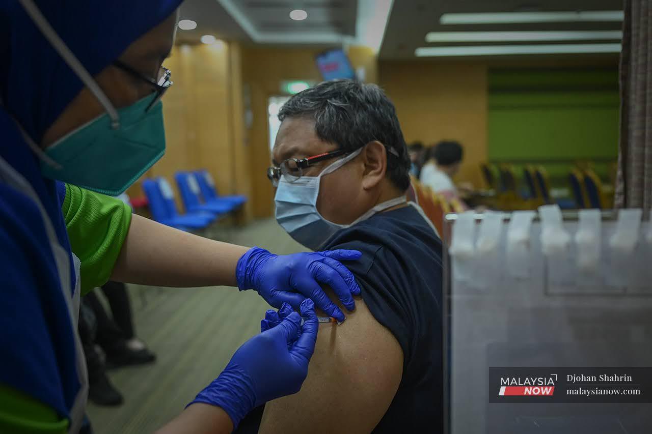 A health worker receives a booster jab of Pfizer vaccine at KPJ Tawakkal in Jalan Pahang, Kuala Lumpur.