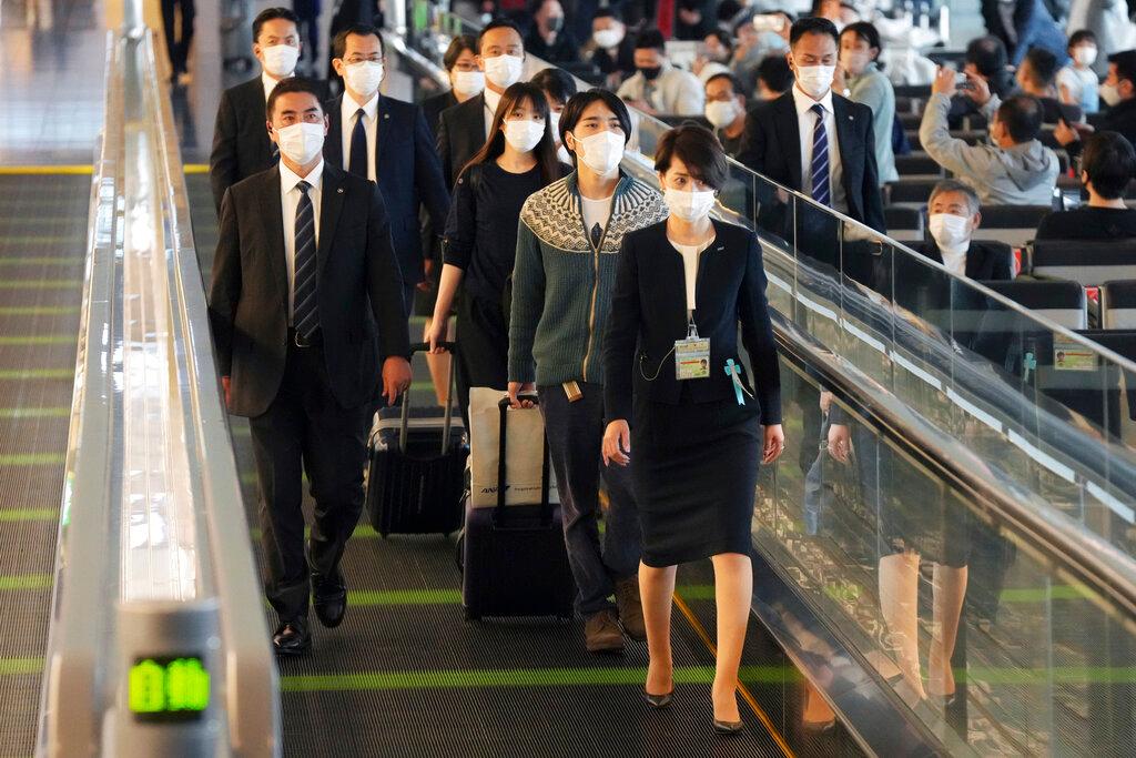 Japan's former Princess Mako, third right, the elder daughter of Crown Prince Akishino, and her husband Kei Komuro, second right, are escorted to board an airplane to New York, Nov 14, at Tokyo International Airport in Tokyo. Photo: AP
