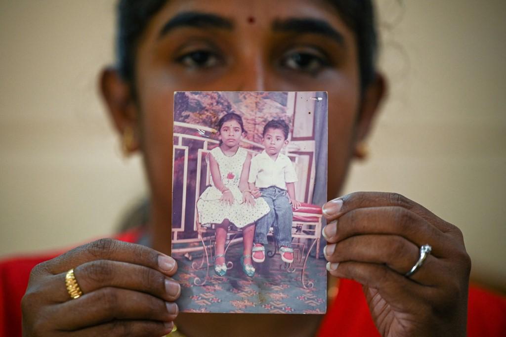 Sarmila Dharmalingam, the elder sister of Nagaenthran K Dharmalingam who has been sentenced to death for trafficking drugs into Singapore, holds up a photo of them together as children. Photo: AFP