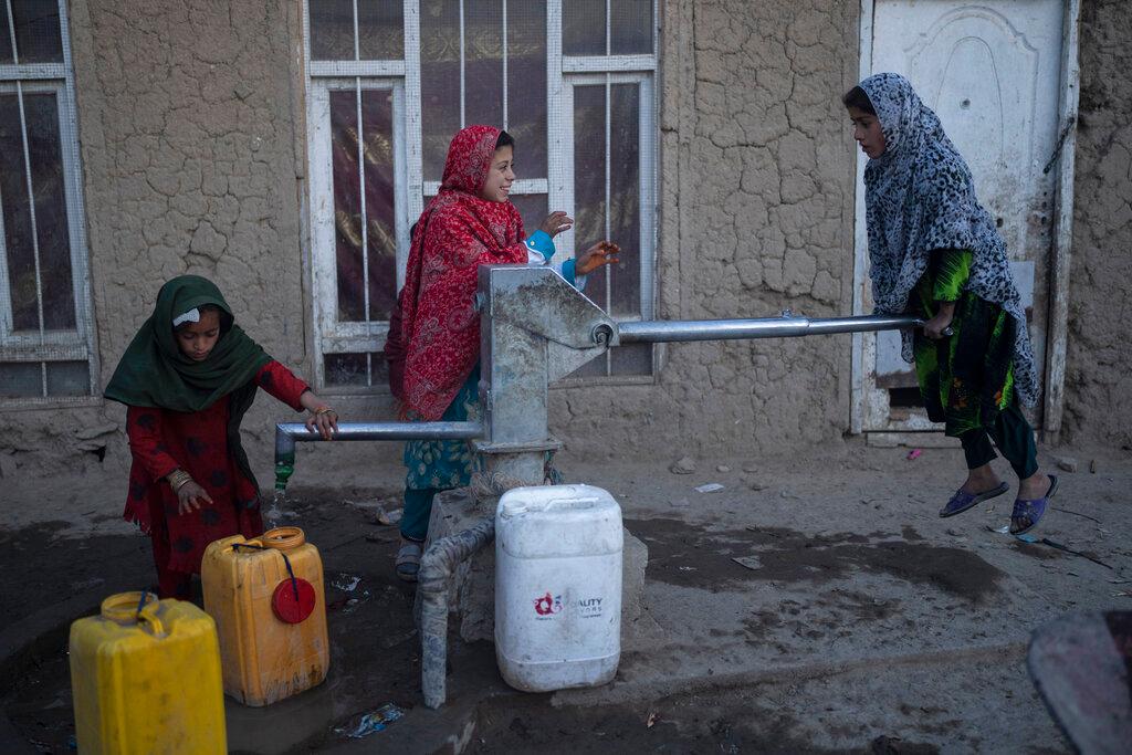 Girls fill containers with water using a hand pump at a camp for internally displaced people, in Kabul, Afghanistan, Nov 15. Crime, nepotism and corruption are not new in Afghanistan but rising poverty is undermining the Taliban government's claim to legitimacy. Photo: AP