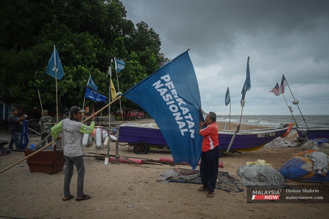 Villagers put up a giant Perikatan Nasional flag at the beach in Pengkalan Balak, Tanjung Bidara ahead of the Melaka state election on Saturday.