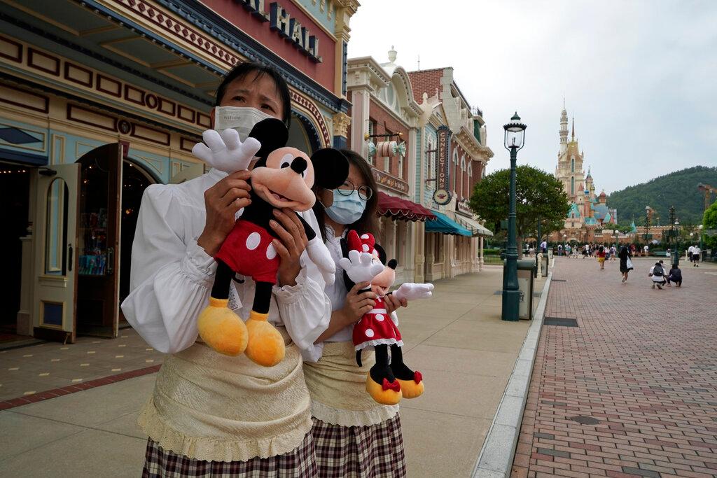 Employees wearing face masks welcome visitors to Hong Kong Disneyland in this Sept 25, 2020 file photo. Photo: AP