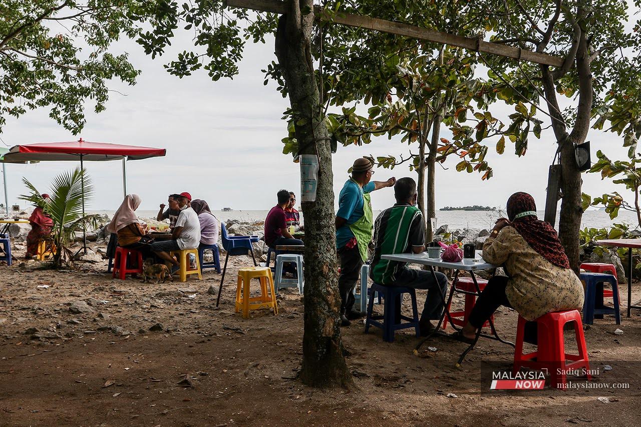 Customers stop for a meal at stalls set up along Pantai Siring in Serkam, Melaka. Serkam has traditionally been seen as an Umno-Barisan Nasional stronghold.