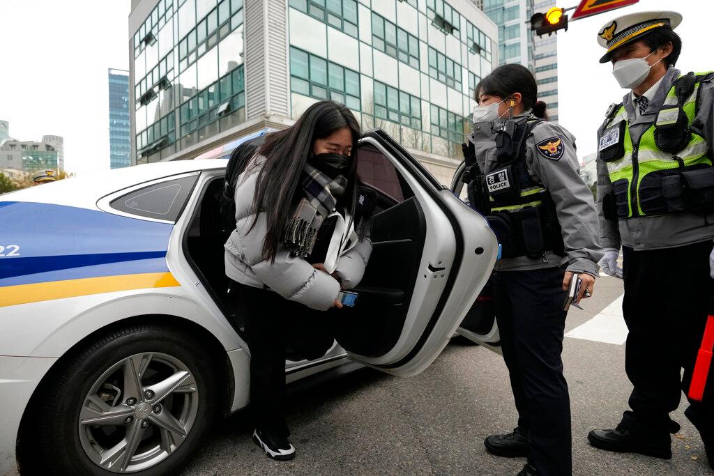 A student gets out of a police vehicle which carried her to a high school to arrive in time for a college entrance exam in Seoul, South Korea, Nov 18. Photo: AP