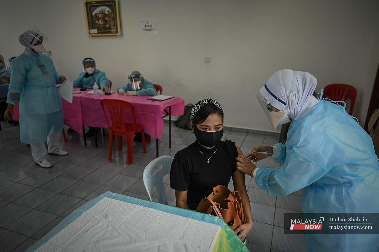 Petugas kesihatan Hospital Orang Asli Gombak, memberi suntikan vaksin Pfizer Bio-NTech bagi dos kedua kepada Orang Asli Temuan di Sungai Congkak, Hulu Langat.