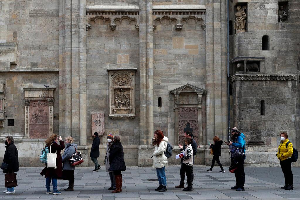 People line up for vaccination in front of the St Stephen's Cathedral in Vienna, Austria, Nov 19. Austria is heading into a national lockdown next week in a bid to contain a fourth wave of Covid-19. Photo: AP