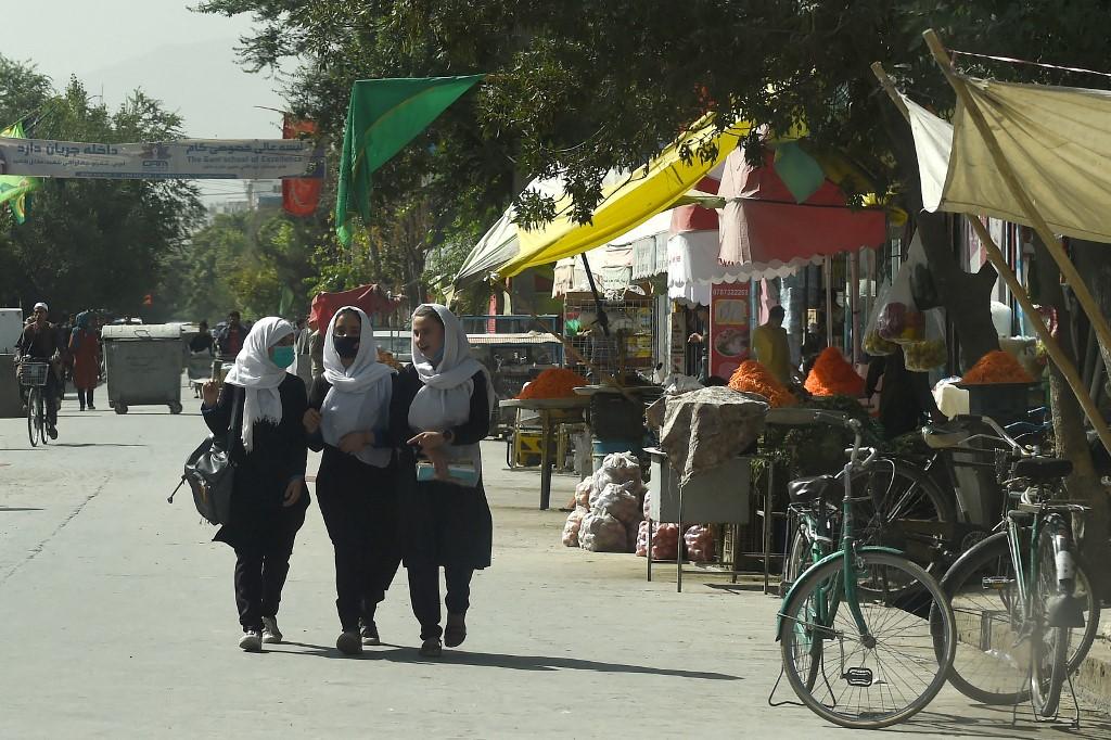 Afghan schoolgirls walk through in a street in Kabul on Aug 15. The UN has repeatedly warned since the Taliban took over that Afghanistan's economy is on the brink of a collapse that would likely further fuel a refugee crisis. Photo: AFP