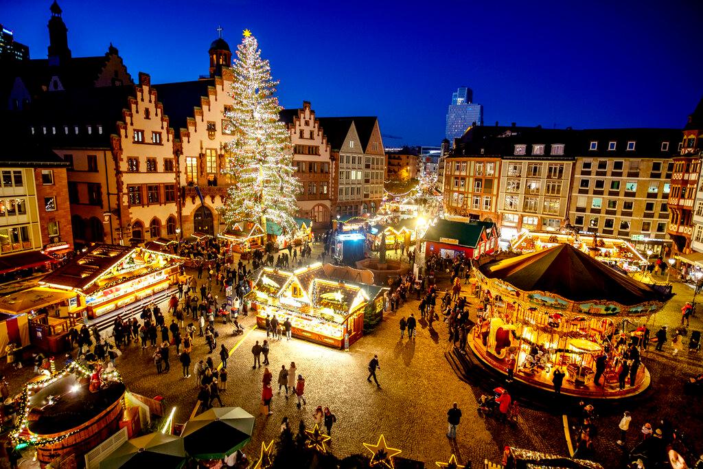 Lights illuminate the Christmas market in Frankfurt, Germany, Nov 22. Due to the Covid-19 pandemic the opening ceremony was cancelled, fewer booths were set up and police checked if visitors stuck to the coronavirus restrictions. Photo: AP