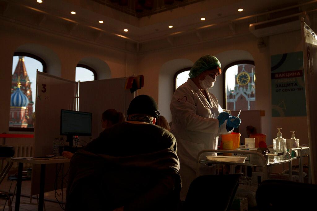 A medical worker prepares a shot of Russia's Sputnik Lite coronavirus vaccine at a vaccination centre in the GUM, State Department store, in Red Square with the Spasskaya Tower (right) and the St Basil Cathedral in the background, in Moscow, Russia, Oct 26. Photo: AP