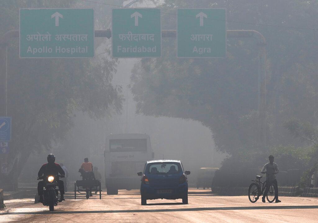 A motorcyclist drives on the wrong side of the road amidst morning haze and toxic smog in New Delhi, India, Nov 17. Delhi's foul air is putting more children in hospital with breathing problems, raising concerns among parents. Photo: AP