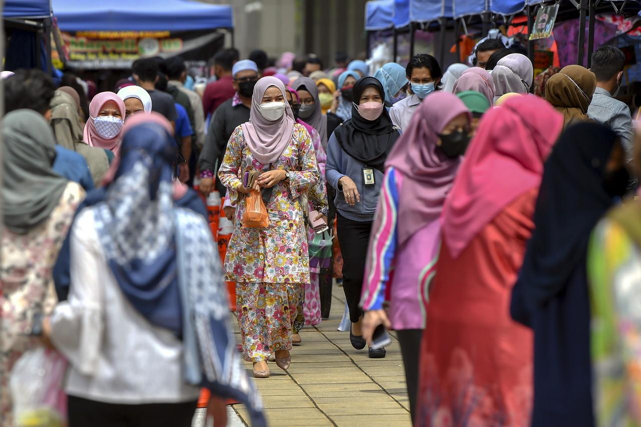 People wearing face masks to curb the spread of Covid-19 stroll through a market area in Putrajaya, Nov 25. Photo: Bernama
