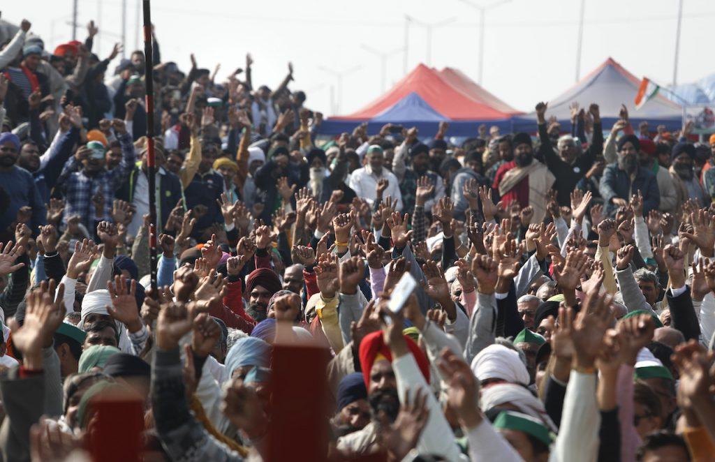 Farmers raise their hands as they shout slogans during a day-long hunger strike to protest against new farm laws, at the Delhi-Uttar Pradesh border on the outskirts of New Delhi, India, Jan 30. Tens of thousands of protesters have been sitting in encampments for the last one year, braving a scorching summer, frigid winter and a severe second wave of coronavirus infections. Photo: AP