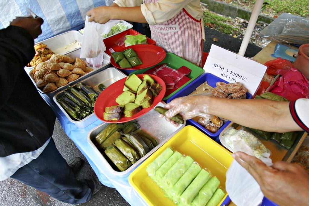 Customers choose from a variety of kuih at a stall in Kuala Lumpur, in this 2005 file photo. Fewer people are still making traditional kuih these days as many of the younger generation turn to more trendy, Western-style desserts. Photo: AFP