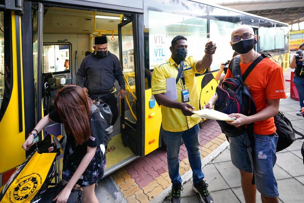 Seorang pengendali bas memeriksa tiket penumpang di stesen bas Larkin di Johor Bahru hari ini. Malaysia dan Singapura telah membuka semula sebahagian sempadan untuk warganegara yang telah divaksin lengkap, selepas hampir dua tahun ditutup kerana pandemik. Gambar: AP