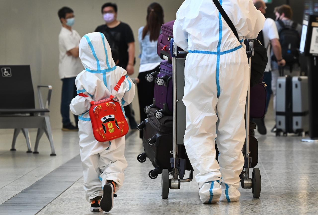 International travellers wearing personal protective equipment arrive at Melbourne's Tullamarine Airport on Nov 29 as Australia records its first cases of the Omicron variant of Covid-19. Photo: AFP