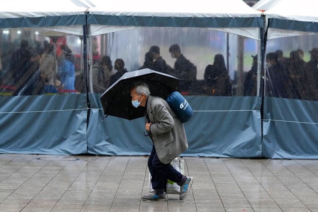 A man wearing a face mask passes by a makeshift Covid-19 testing site in Seoul, South Korea, Nov 30. Photo: AP