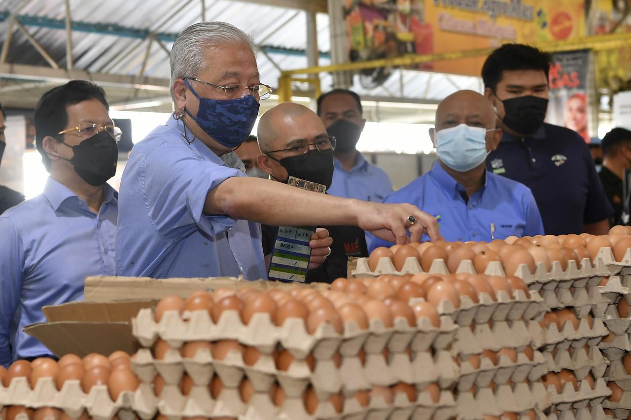 Prime Minister Ismail Sabri Yaakob conducts a price check at MyFarm Outlet Kasih in Putrajaya today, accompanied by Agriculture and Food Industries Minister Ronald Kiandee (third left). Photo: Bernama