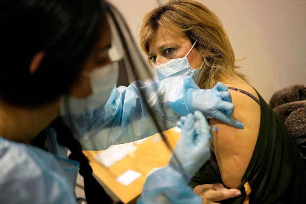 A nurse administers a booster shot of the Pfizer vaccine against Covid-19 to a fellow nurse on the first day of a new vaccination centre in Lisbon, Dec 1. Photo: AP