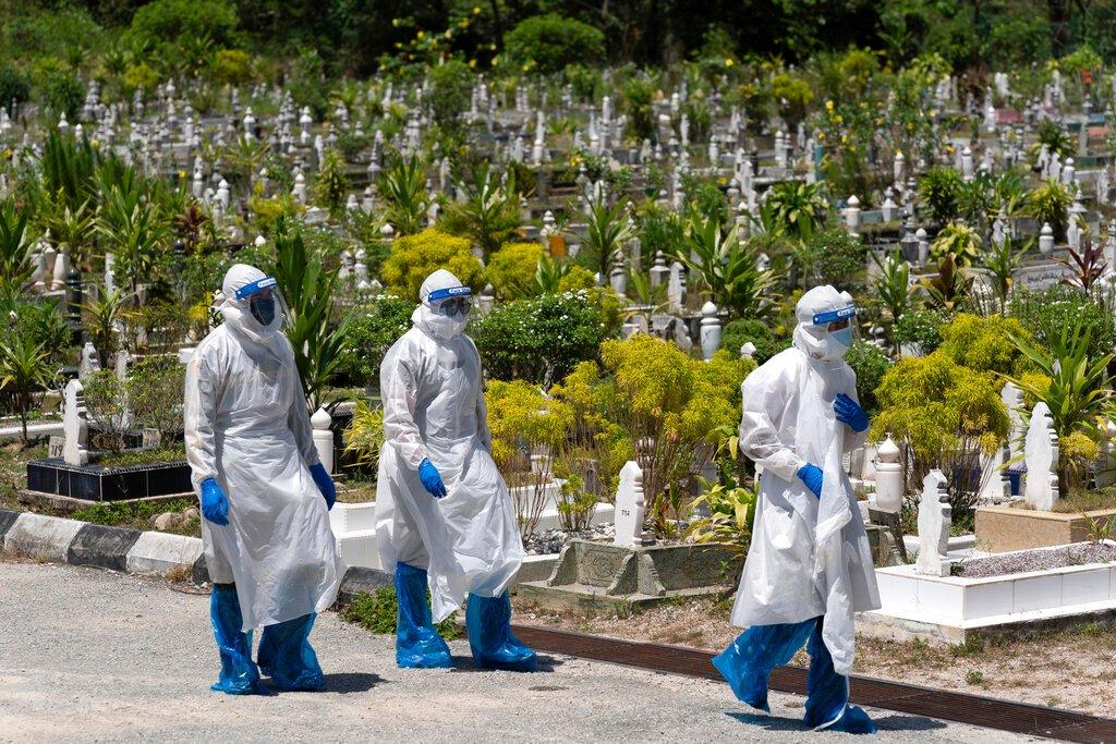 Workers wearing personal protective equipment leave after burying a Covid-19 victim at a Muslim cemetery in Gombak in this Feb 5 file photo. Photo: AP