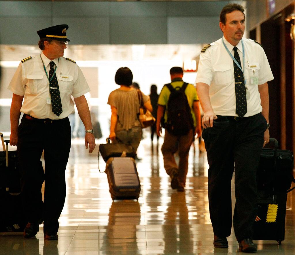 In this Nov 30, 2011, file photo, two pilots from Cathay Pacific walk in the Hong Kong International Airport. Pilots have some exemptions for inbound travel into Hong Kong but spend days, sometimes weeks, shuttling within plane-to-hotel bubbles to avoid triggering quarantine when they return. Photo: AP