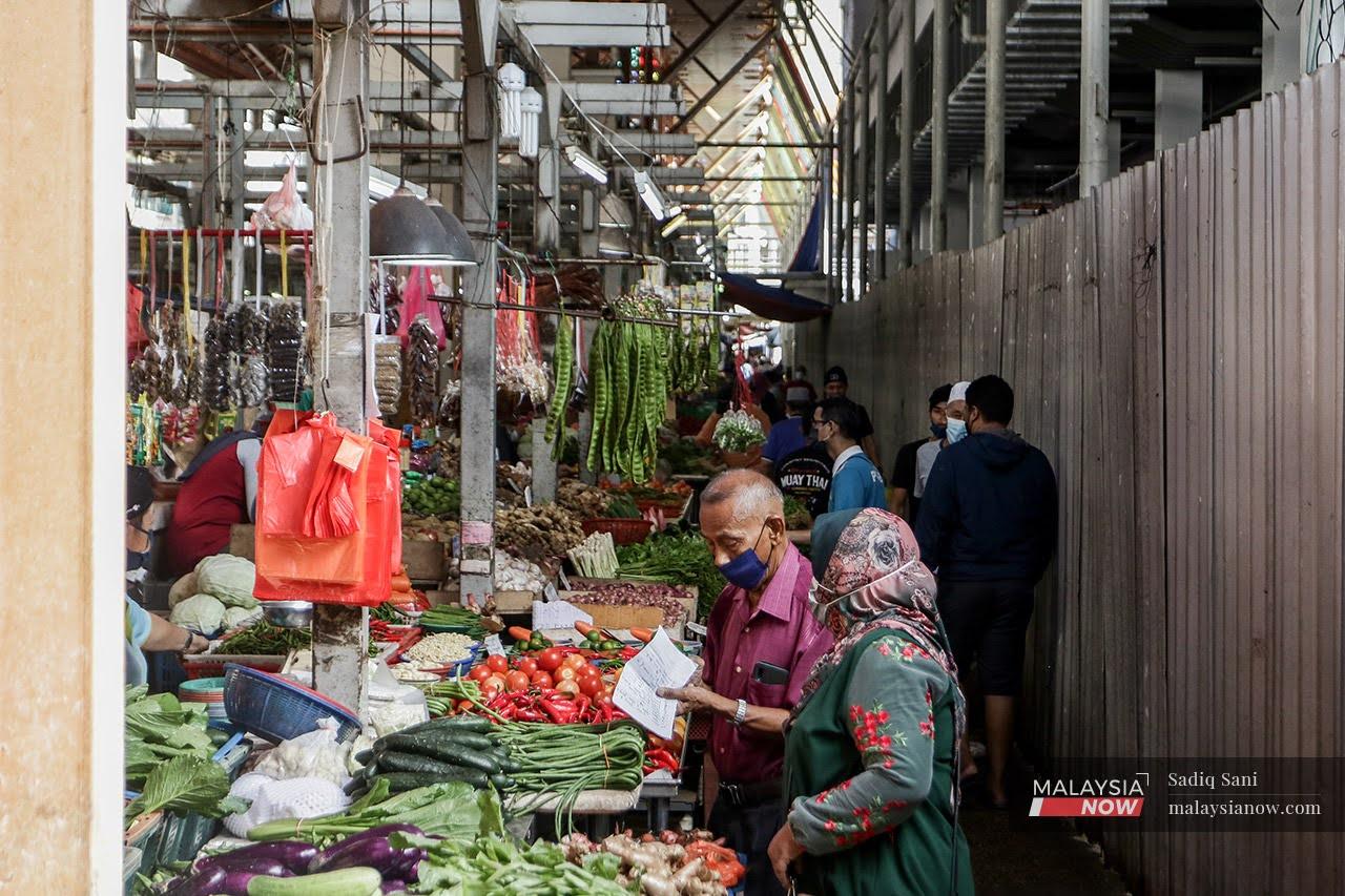 Customers choose from the array of vegetables on display at morning market in Jalan Raja Bot, Kuala Lumpur.