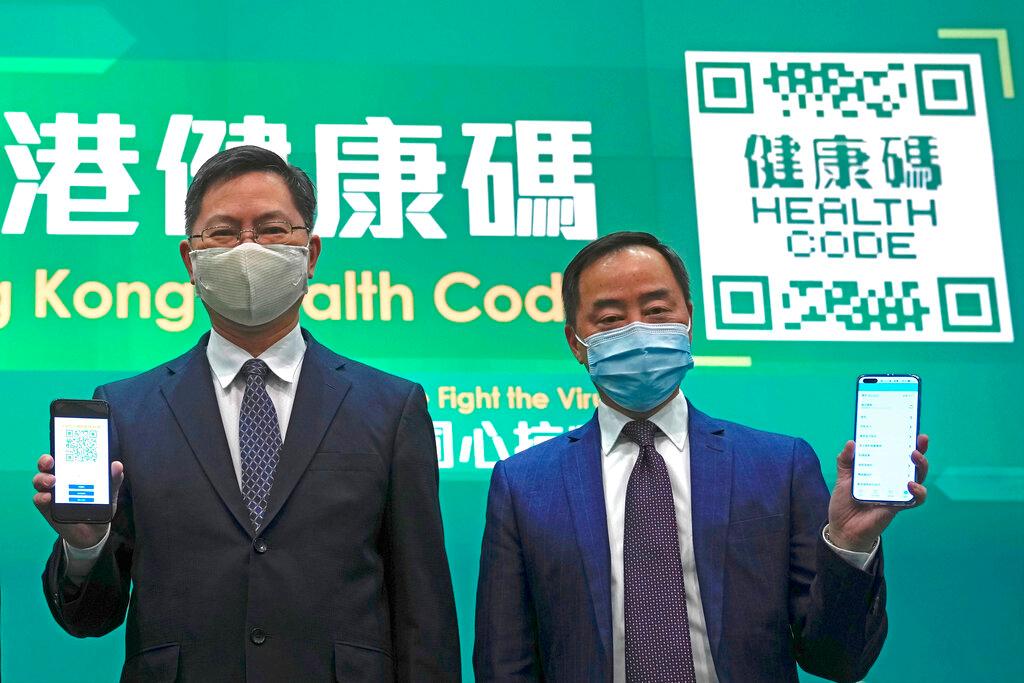 Secretary for Innovation and Technology Alfred Sit, left, and Deputy Government Chief Information Officer Tony Wong hold mobile phones to unveil a new Covid-19 tracking health code mobile app during a news conference in Hong Kong, Dec 2. Photo: AP