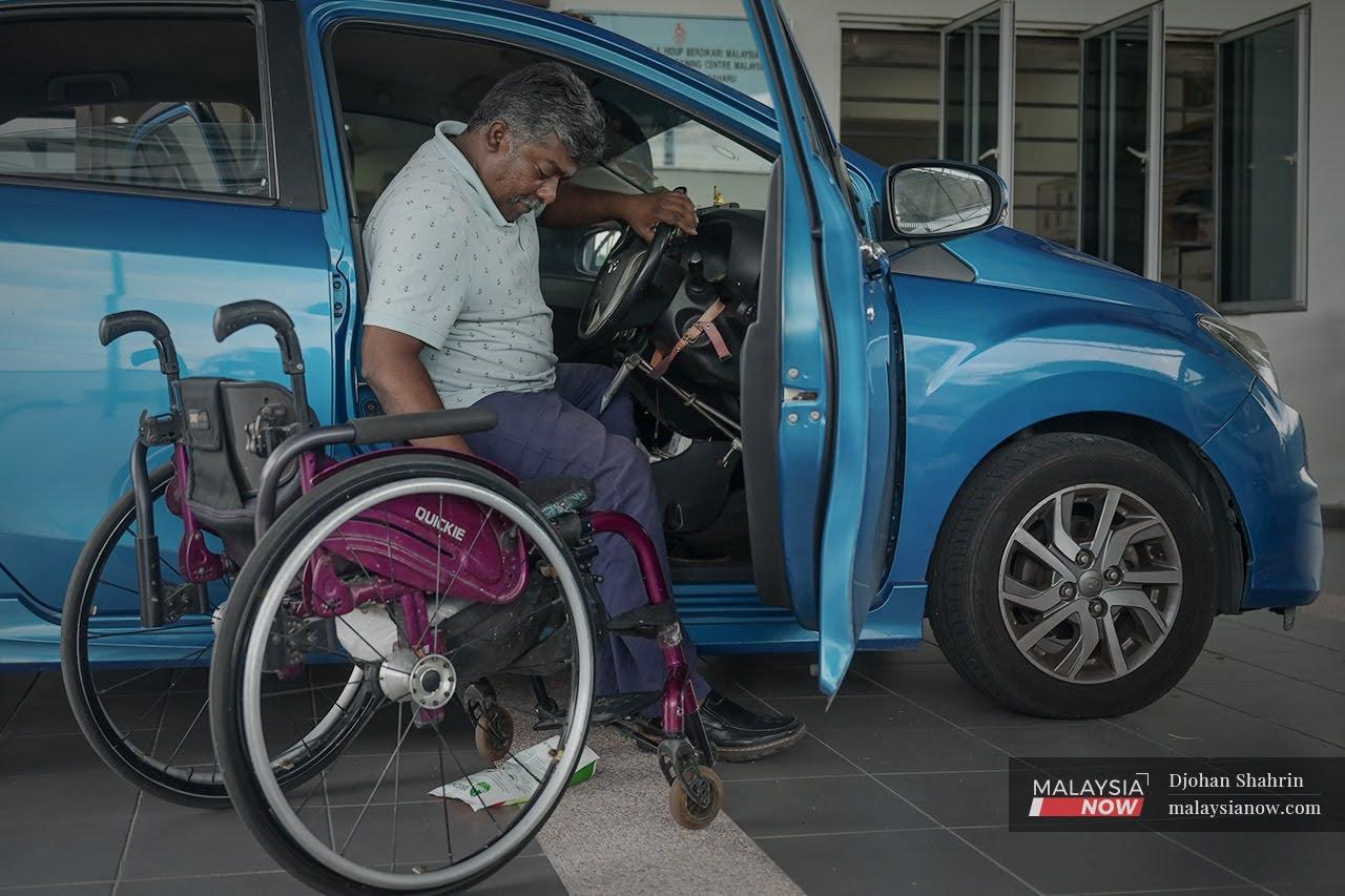 Jeyaraj Santraju manoeuvres his way from his wheelchair into his car before heading off to work in Kampung Sungai Bakau, Rawang.