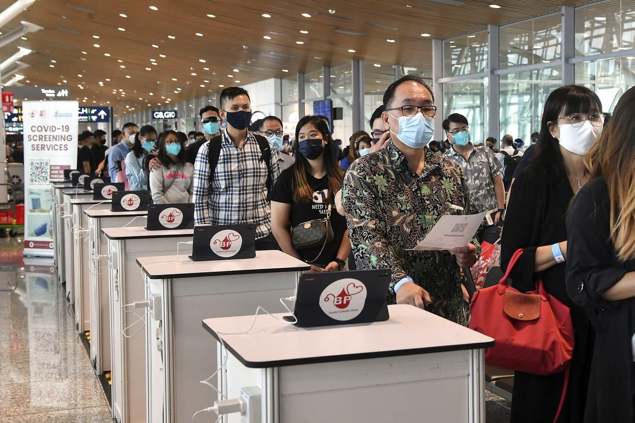 Passengers from Singapore queue to register before being screened for Covid-19 upon their arrival at KLIA in Sepang. Photo: Bernama