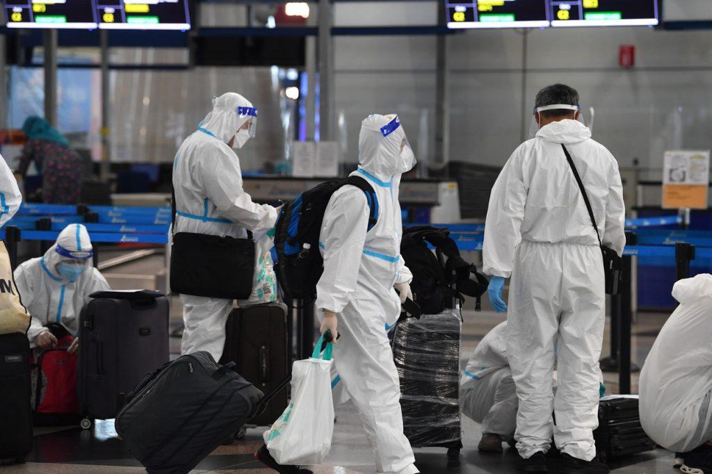 Suasana penumpang yang menunggu bagasi di KLIA. Penumpang penerbangan antarabangsa turut memakai pakaian pelindung lengkap bagi mengelak jangkitan Covid-19. Gambar: Bernama