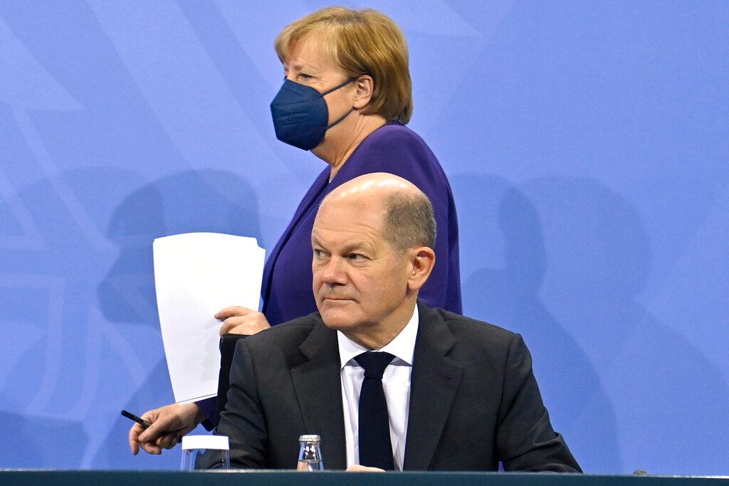 German Chancellor Angela Merkel (background) and Finance Minister Olaf Scholz arrive for a press conference following a meeting with the heads of government of Germany's federal states at the Chancellery in Berlin, Dec 2. Photo: AP