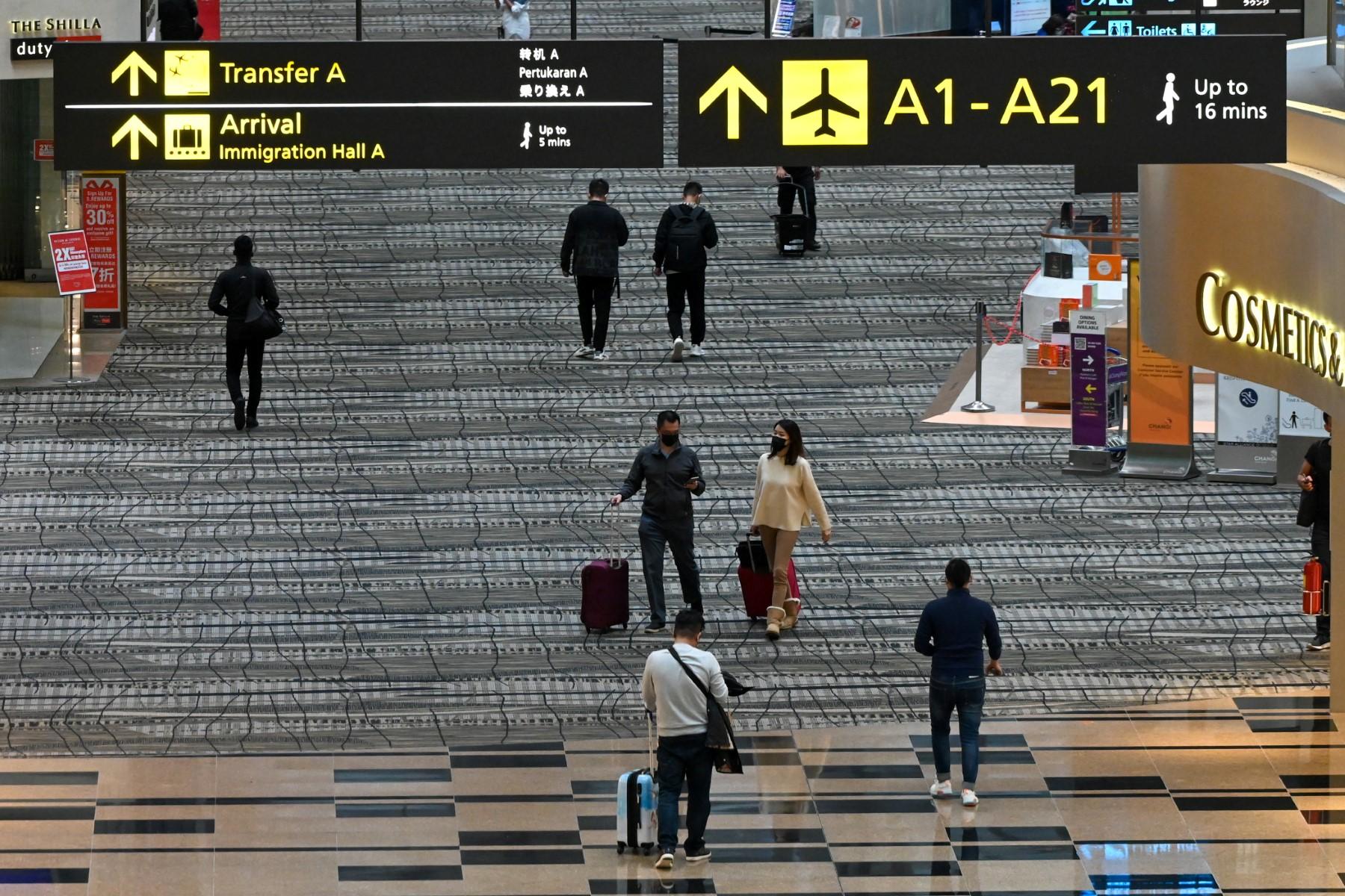 Travellers walk through the transit hall at Changi International Airport in Singapore on Dec 2. Photo: AFP