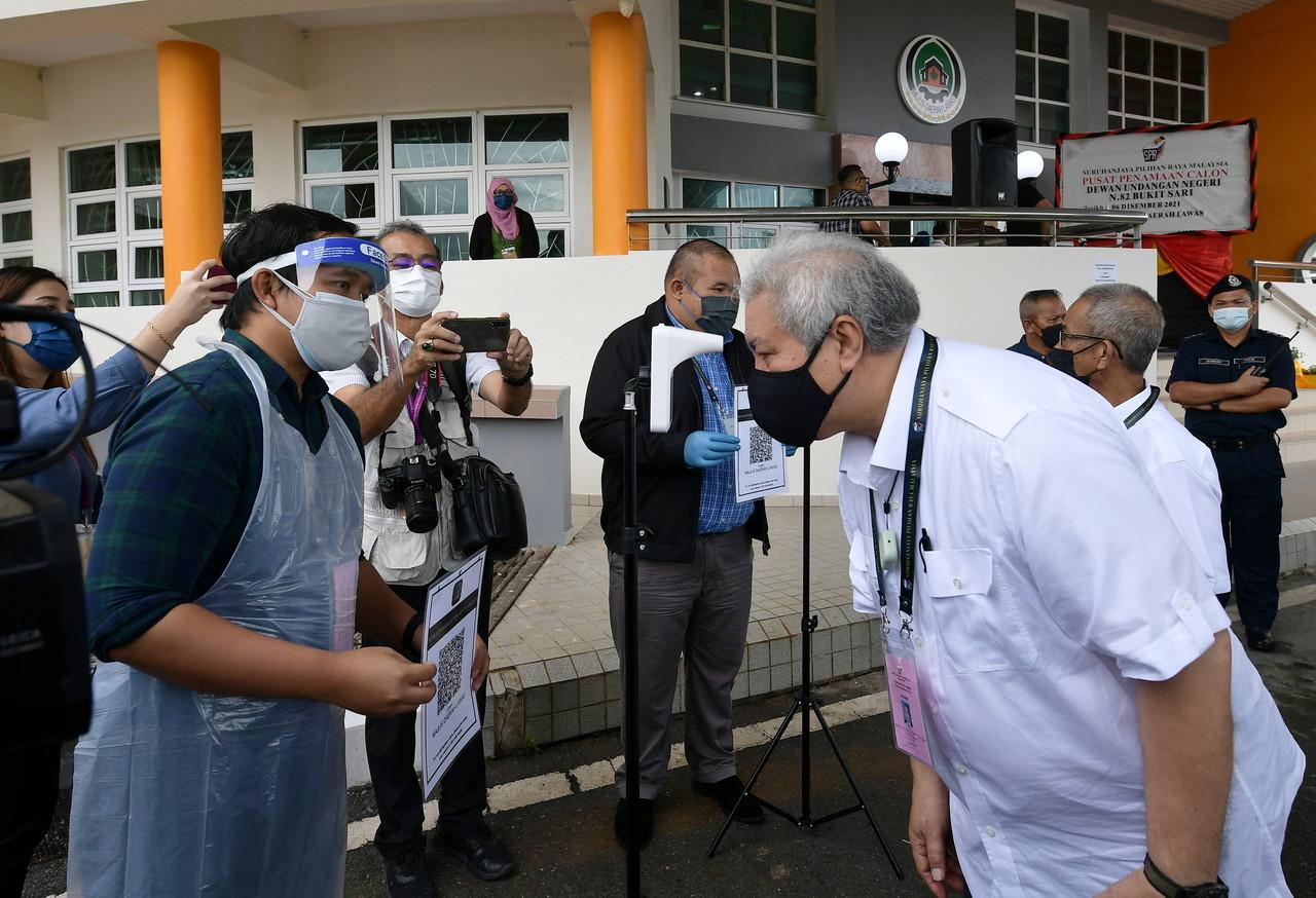 Sarawak Deputy Chief Minister Awang Tengah Ali Hasan checks his temperature at the nomination centre at the Lawas District Council building today. Photo: Bernama