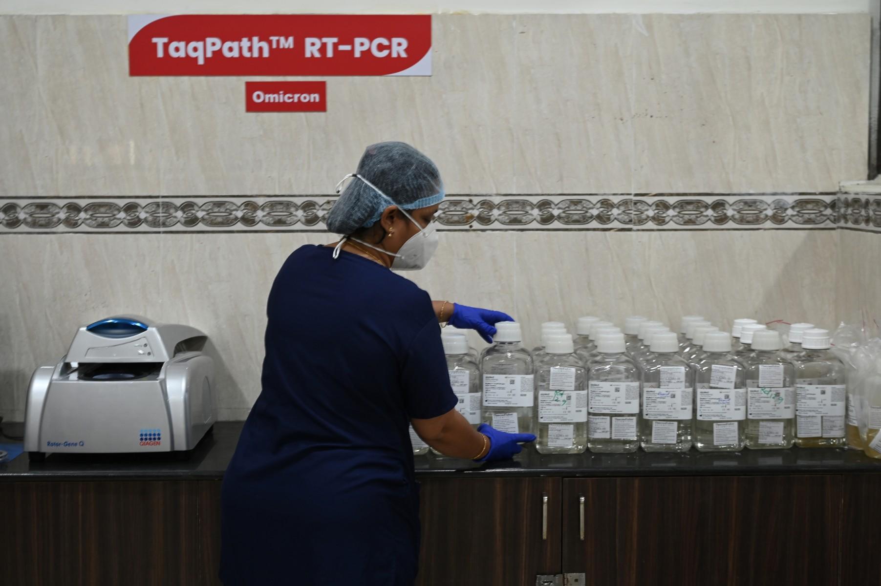 A lab technician works inside a pathological lab equipped to screen Covid-19 patients and patients infected with the Omicron variant arriving from listed high-risk destinations at a government hospital in Chennai, India on Dec 6. Photo: AFP
