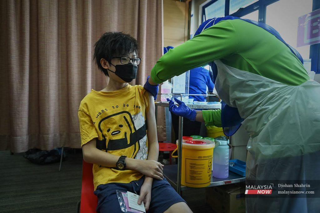 A health worker administers a jab of Pfizer vaccine to a teenager at KPJ Tawakkal in Jalan Pahang, Kuala Lumpur.